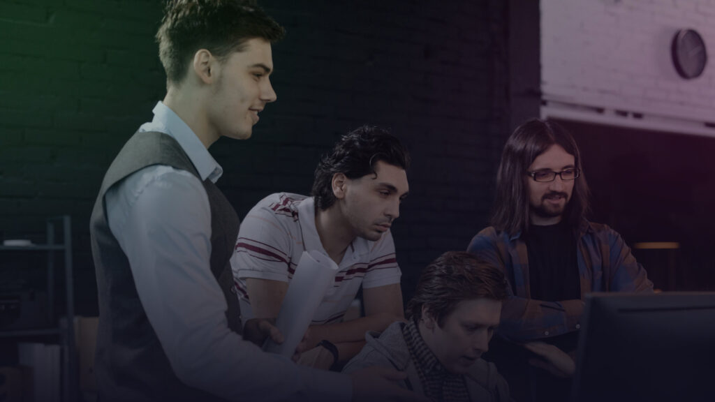 Team überprüft gemeinsam eine Aufgabe am Computer.