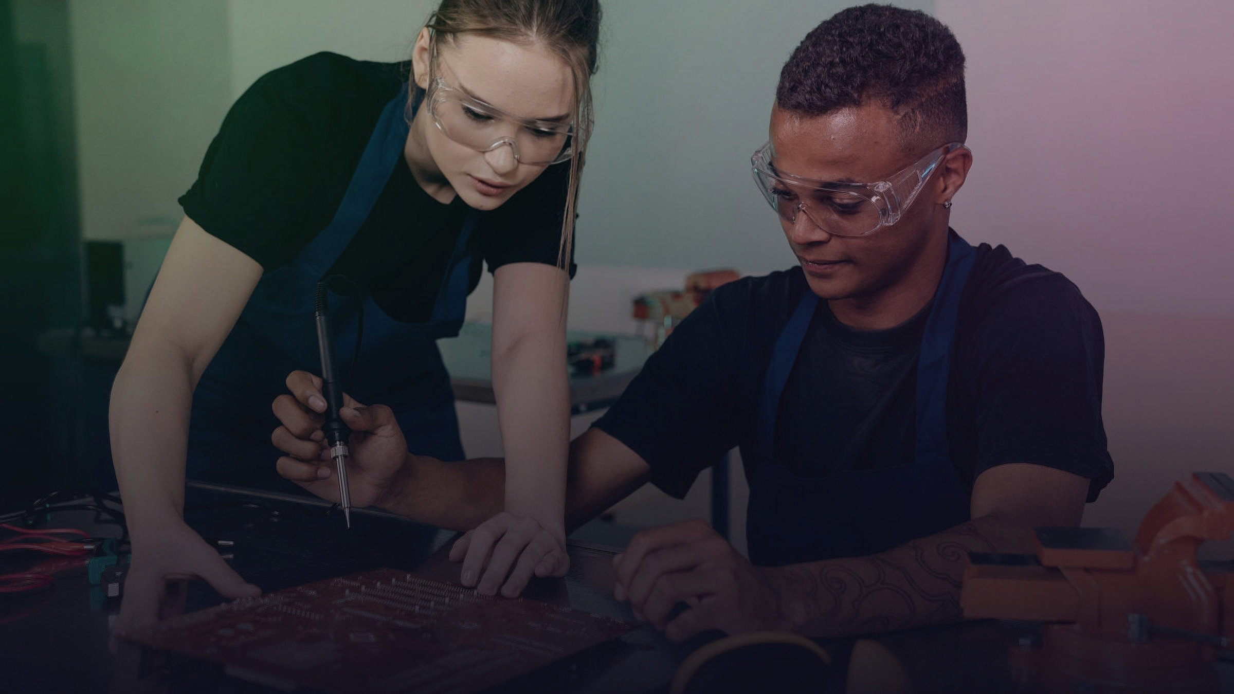 Zwei Ingenieure arbeiten gemeinsam an einer Leiterplatte.